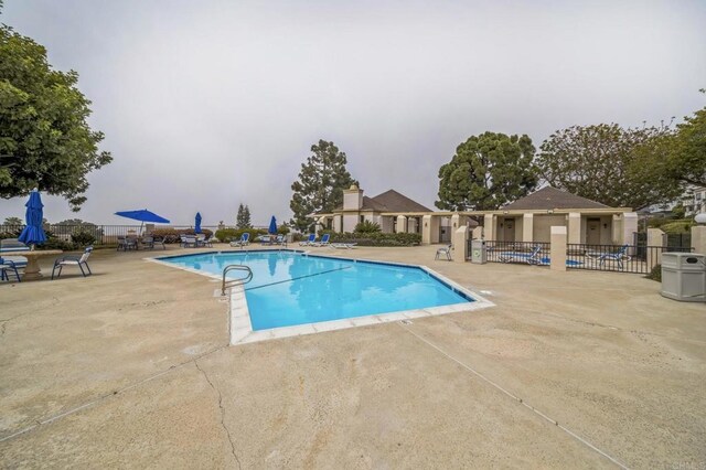 pool with a patio and fence