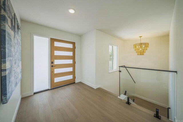 entryway featuring recessed lighting, baseboards, an inviting chandelier, and wood finished floors