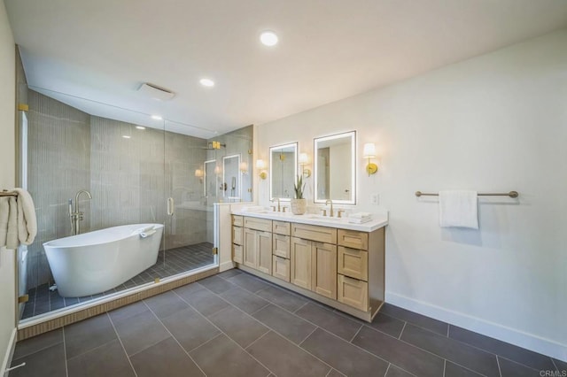 full bathroom with a shower stall, tile patterned flooring, a sink, a freestanding bath, and double vanity