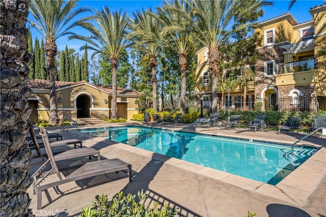 pool featuring fence and a patio area
