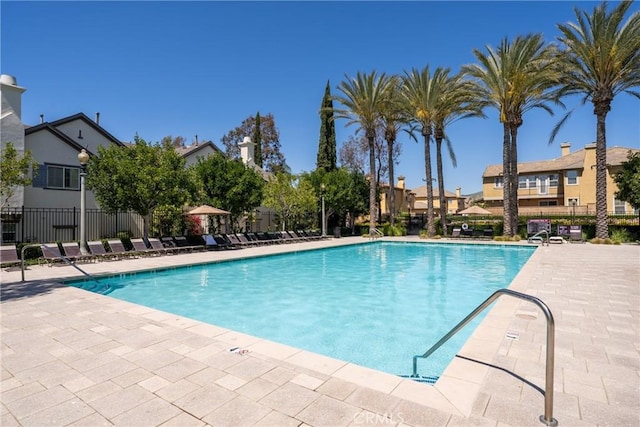 pool with a residential view, a patio, and fence