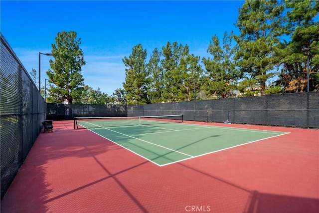 view of tennis court with fence and community basketball court