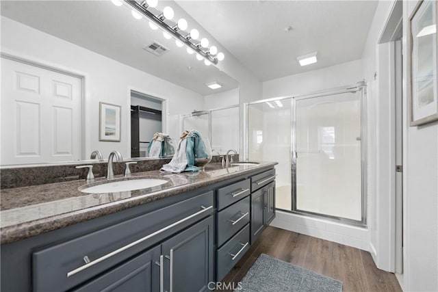 bathroom featuring visible vents, a sink, and a stall shower