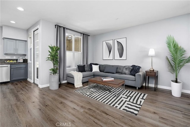 living room featuring baseboards, wood finished floors, indoor bar, and recessed lighting