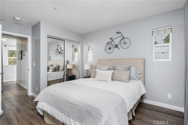 bedroom with wood finished floors, baseboards, and a closet