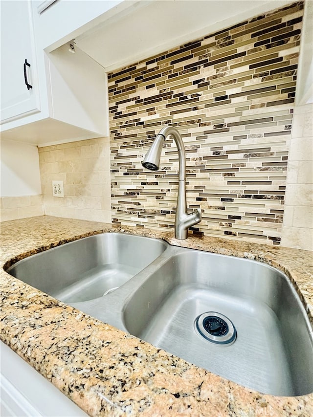 2019 Via Mariposa W Unit G, Laguna Woods, CA 92637 - kitchen view of a sink, decorative backsplash, white cabinetry, and light stone countertops