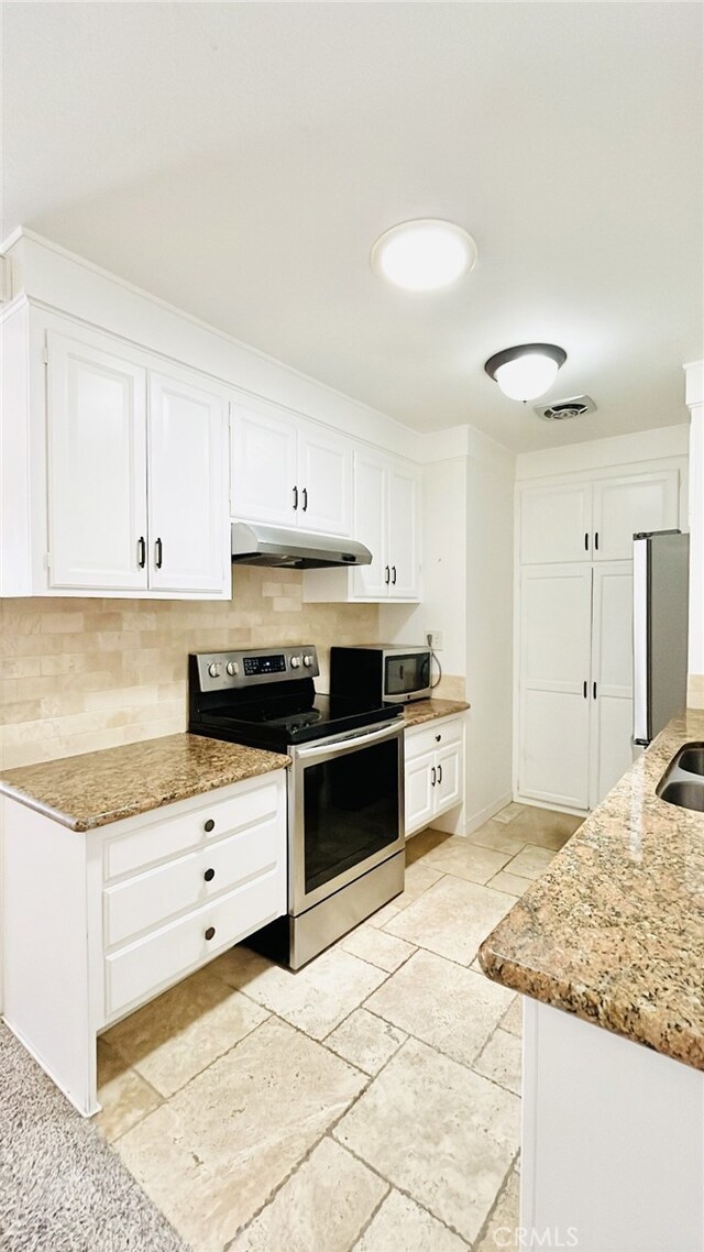 2019 Via Mariposa W Unit G, Laguna Woods, CA 92637 - kitchen with appliances with stainless steel finishes, under cabinet range hood, tasteful backsplash, and light stone countertops