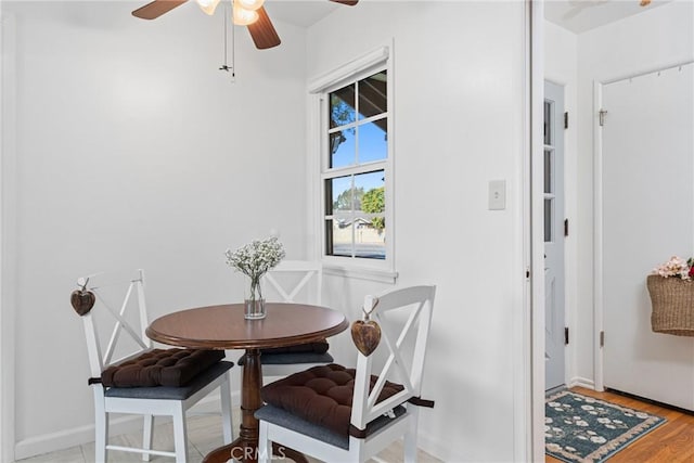 dining room with wood finished floors, baseboards, and a ceiling fan