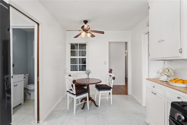 dining space featuring baseboards and a ceiling fan