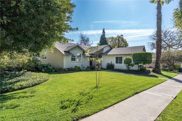 ranch-style home featuring board and batten siding and a front yard