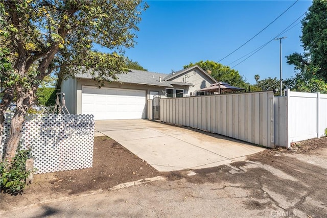 exterior space with a garage, driveway, fence, and a gate