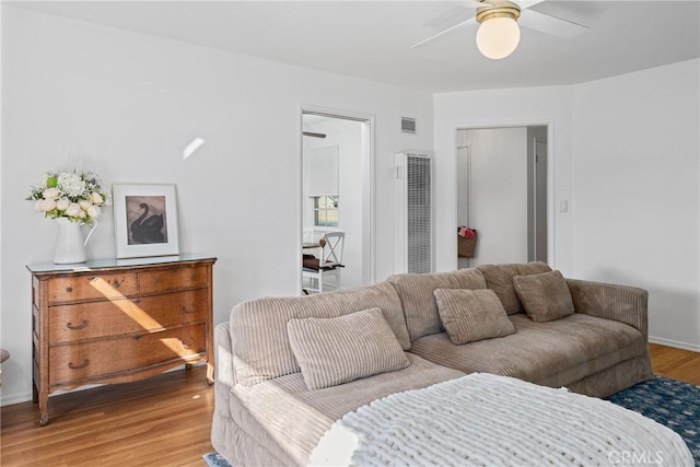 living area featuring light wood-style floors, ceiling fan, baseboards, and visible vents
