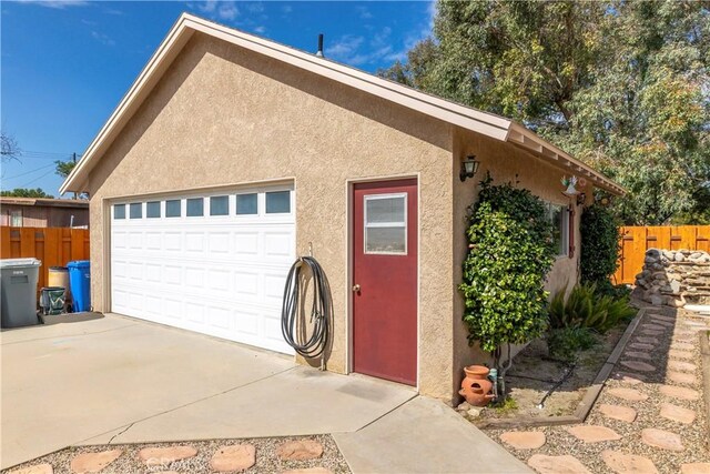 250 N Wateka St, San Jacinto, CA 92583 - view of side of property with stucco siding, fence, and a garage
