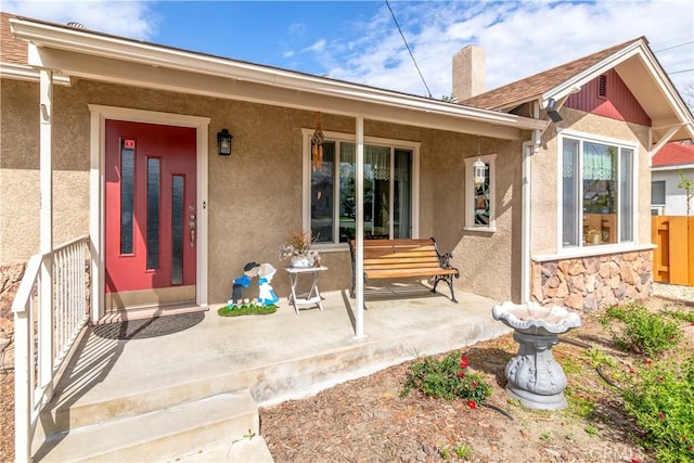 250 N Wateka St, San Jacinto, CA 92583 - doorway to property with stucco siding, a porch, a chimney, and fence
