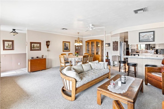 250 N Wateka St, San Jacinto, CA 92583 - living area with light carpet, a chandelier, ceiling fan, ornamental molding, and a wainscoted wall