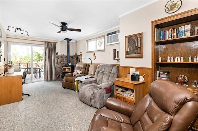250 N Wateka St, San Jacinto, CA 92583 - living room with a wood stove, a wall mounted air conditioner, crown molding, ceiling fan, and wainscoting