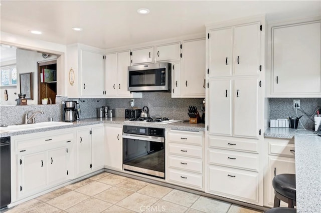 250 N Wateka St, San Jacinto, CA 92583 - kitchen featuring appliances with stainless steel finishes, a sink, decorative backsplash, white cabinetry, and recessed lighting