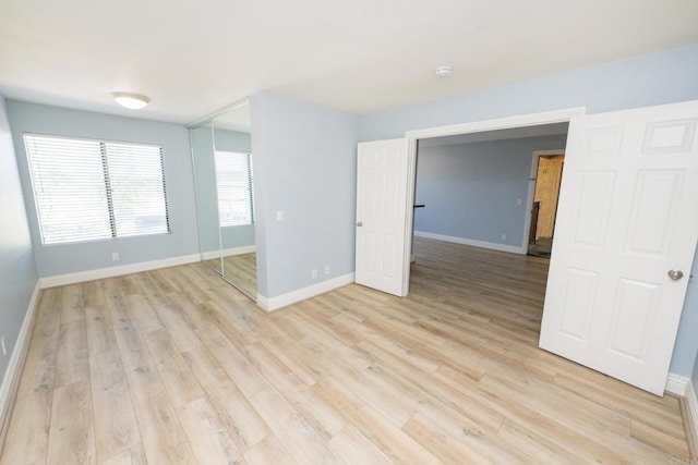 unfurnished room with light wood-style floors and baseboards