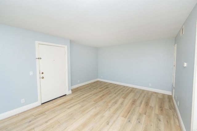 spare room featuring light wood-style flooring and baseboards