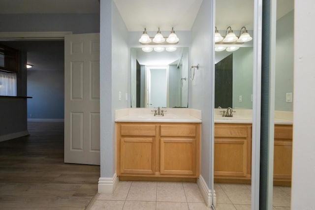 full bath with two vanities and baseboards