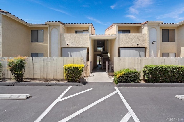 8731 Graves Ave Unit 13, Santee, CA 92071 - view of property featuring uncovered parking, a fenced front yard, and stairway