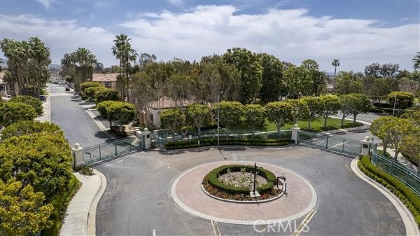 view of property's community with curved driveway, fence, and a gate
