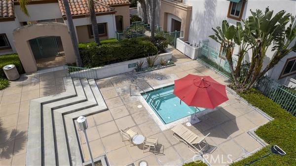 view of swimming pool with a patio and fence