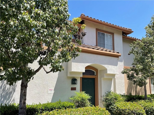 view of front of house with stucco siding and a tiled roof