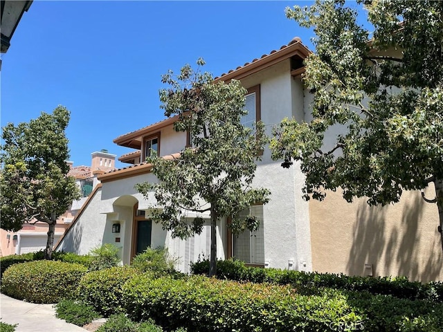 view of front of house with a tile roof and stucco siding