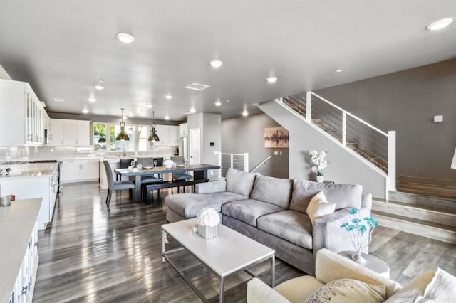 living room featuring visible vents, stairs, dark wood-style floors, and recessed lighting
