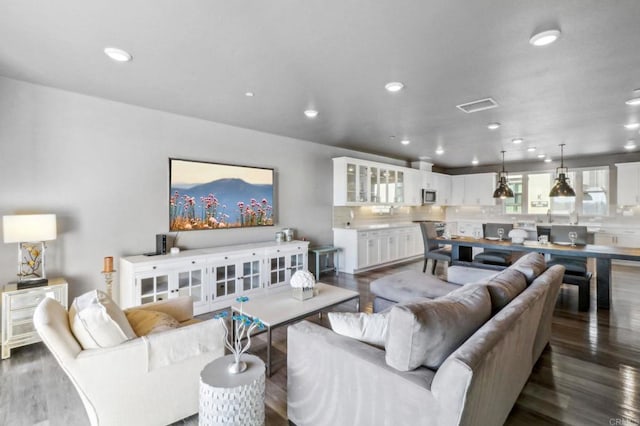 living room featuring recessed lighting, dark wood finished floors, and visible vents