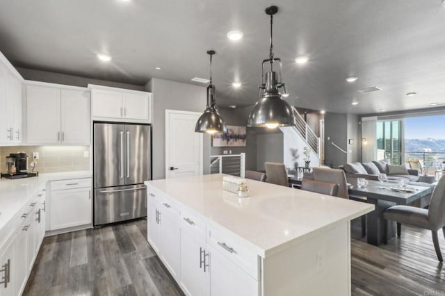 kitchen with backsplash, freestanding refrigerator, a center island, and dark wood-style floors