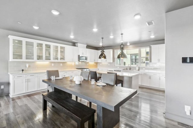 dining space featuring visible vents, baseboards, wood finished floors, and recessed lighting