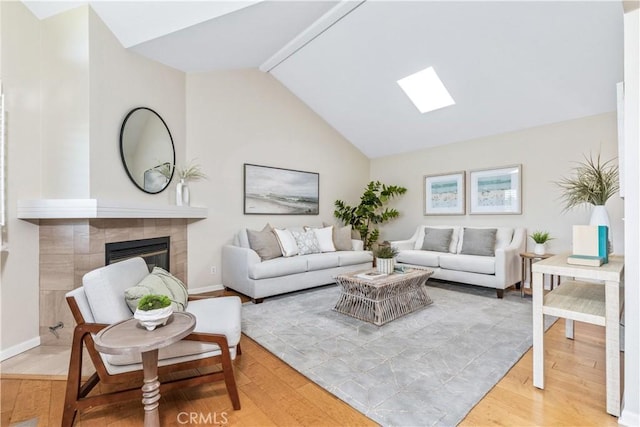 6441 Fiddleneck Ln Unit 23, Avila Beach, CA 93424 - living room featuring light wood-type flooring, vaulted ceiling, baseboards, and a tile fireplace