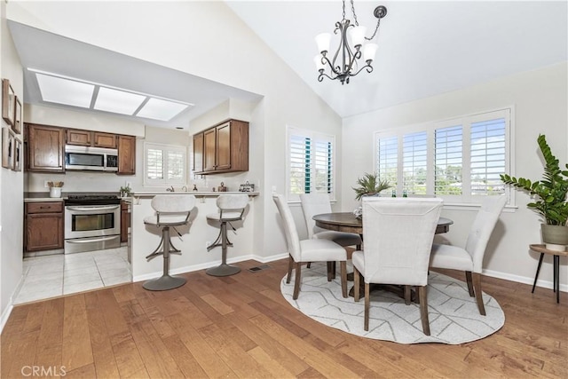 6441 Fiddleneck Ln Unit 23, Avila Beach, CA 93424 - dining area with light wood-type flooring, a chandelier, vaulted ceiling, and baseboards