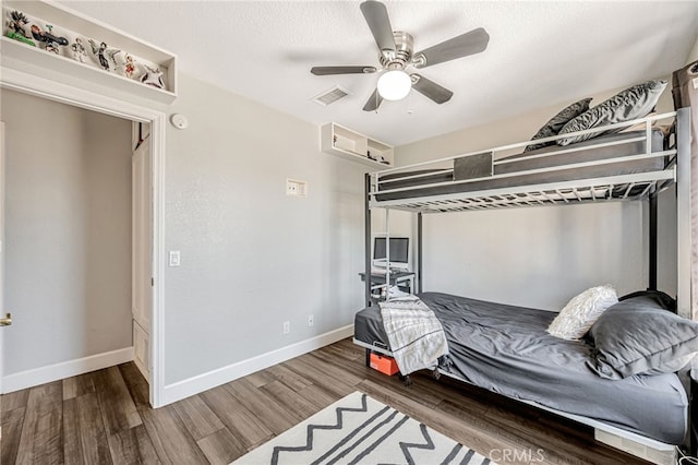 bedroom featuring a textured ceiling, wood finished floors, ceiling fan, and baseboards