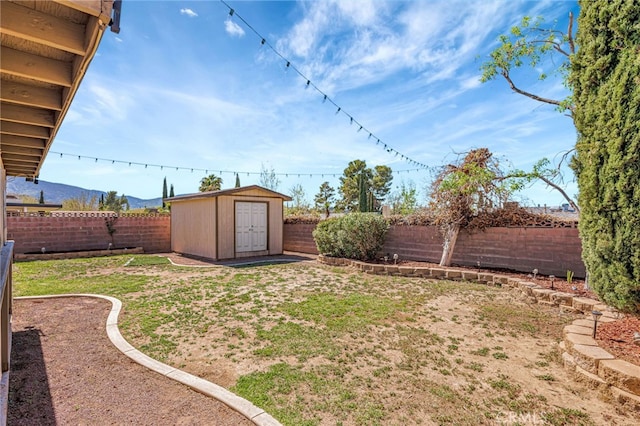 view of yard with a storage shed, an outbuilding, and a fenced backyard