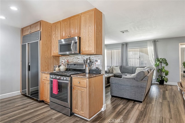 kitchen featuring dark wood finished floors, visible vents, backsplash, and appliances with stainless steel finishes