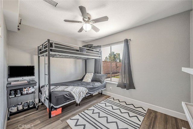 bedroom with visible vents, baseboards, and wood finished floors