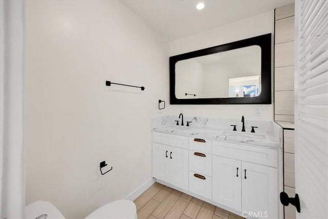 8620 S 4th Ave, Inglewood, CA 90305 - bathroom with toilet, baseboards, double vanity, and wood finished floors