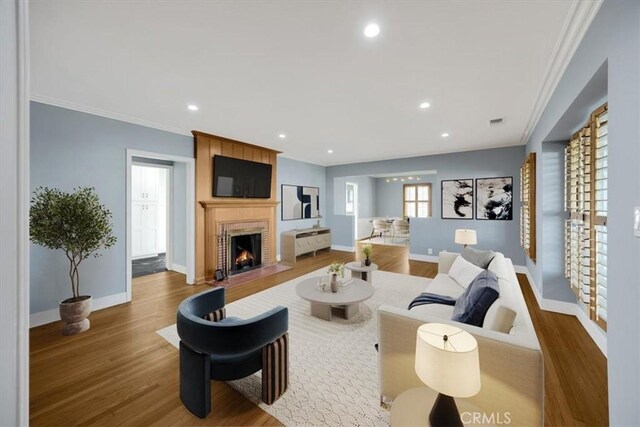 8620 S 4th Ave, Inglewood, CA 90305 - living room featuring wood finished floors, a large fireplace, baseboards, recessed lighting, and ornamental molding