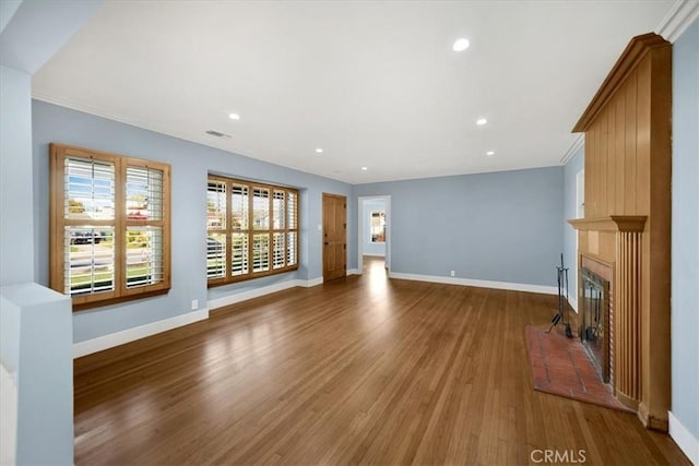 8620 S 4th Ave, Inglewood, CA 90305 - unfurnished living room with wood finished floors, baseboards, a glass covered fireplace, recessed lighting, and crown molding