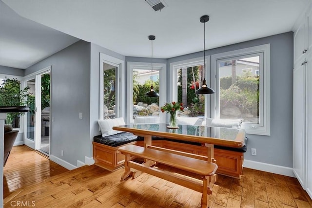 dining room featuring light wood-style floors, baseboards, and visible vents