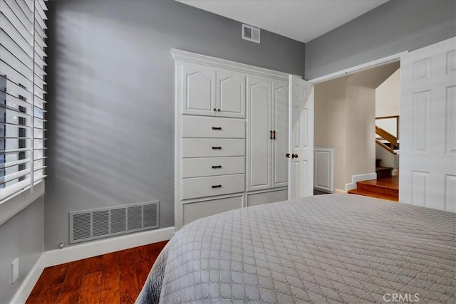 bedroom featuring dark wood-type flooring, baseboards, and visible vents