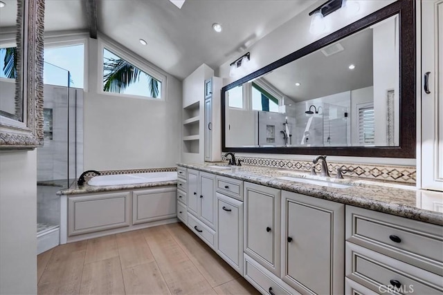 full bathroom featuring a sink, a wealth of natural light, and vaulted ceiling