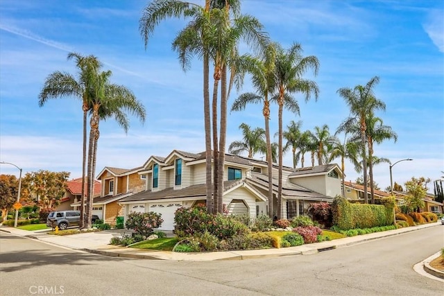 view of front of house with a garage, a residential view, and driveway