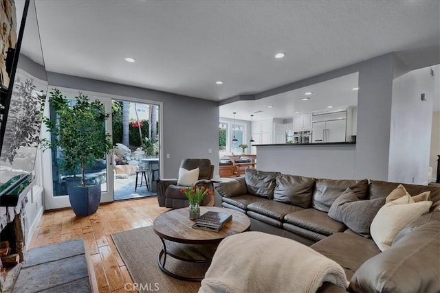 living area with light wood-type flooring and recessed lighting