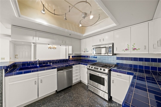35 Linden Unit 302, Long Beach, CA 90802 - kitchen featuring stainless steel appliances, a raised ceiling, white cabinetry, and tile counters