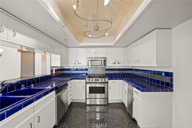 35 Linden Unit 302, Long Beach, CA 90802 - kitchen featuring appliances with stainless steel finishes, a tray ceiling, tile countertops, and white cabinetry