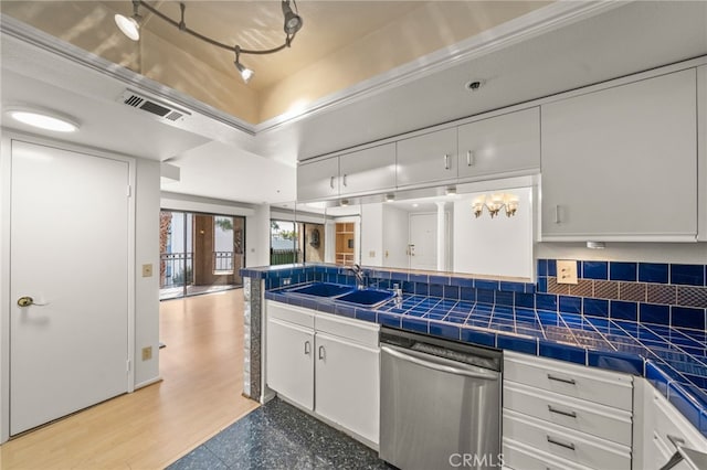 35 Linden Unit 302, Long Beach, CA 90802 - kitchen featuring stainless steel dishwasher, a sink, white cabinetry, tasteful backsplash, and tile counters